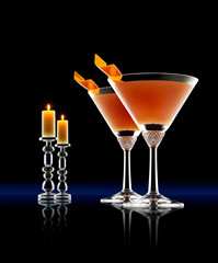 Whisky Rebellion cocktail with orange twist. Black background with candles.