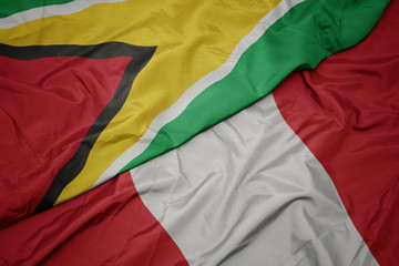 waving colorful flag of peru and national flag of guyana.