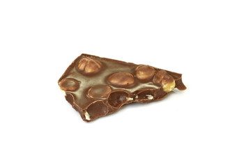 A broken piece of chocolate with hazelnuts isolated on white background. Milk chocolate tiles with nuts isolated on white.