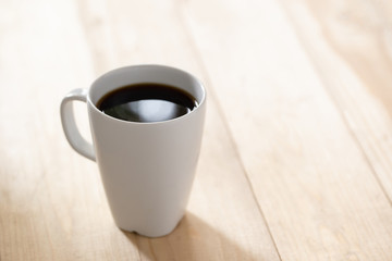 Coffee cup on a blurred wooden board background And free space for entering text