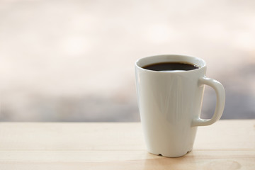 Coffee cup on a blurred wooden board background And free space for entering text