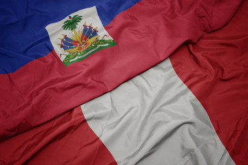 waving colorful flag of peru and national flag of haiti.