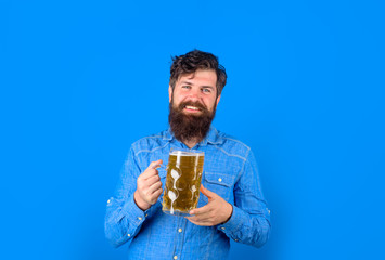 Germany traditions. Man holds cup of beer with foam. Alcohol. Oktoberfest. Beer in glass. Stylish man drinking beer of glass. Beer pub. Lager and dark ale. Bearded man drinking craft ale from mug.