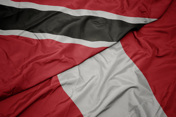 waving colorful flag of peru and national flag of trinidad and tobago.