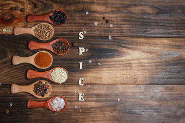 Fototapeta na wymiar Different spices and ingredients in wooden spoons on a wooden table for cooking