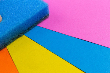 blue and pink dishwasher sponge on a coloured background