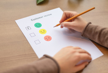 Female ticking on happy smiley face as excellent service