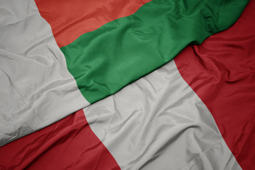 waving colorful flag of peru and national flag of madagascar.