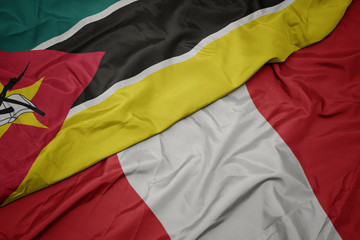 waving colorful flag of peru and national flag of mozambique.