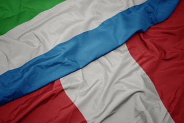 waving colorful flag of peru and national flag of sierra leone.