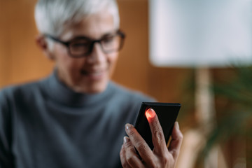 Senior Woman Measuring Pulse or Heart Rate with Smart Phone