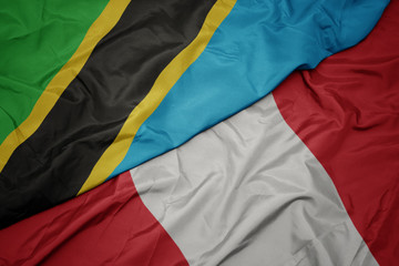 waving colorful flag of peru and national flag of tanzania.