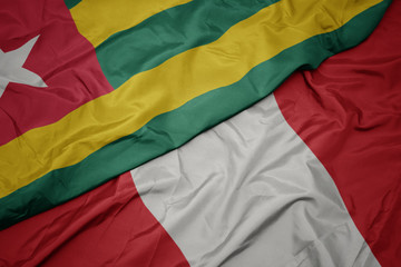 waving colorful flag of peru and national flag of togo.