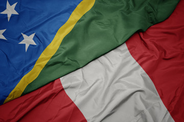 waving colorful flag of peru and national flag of Solomon Islands .