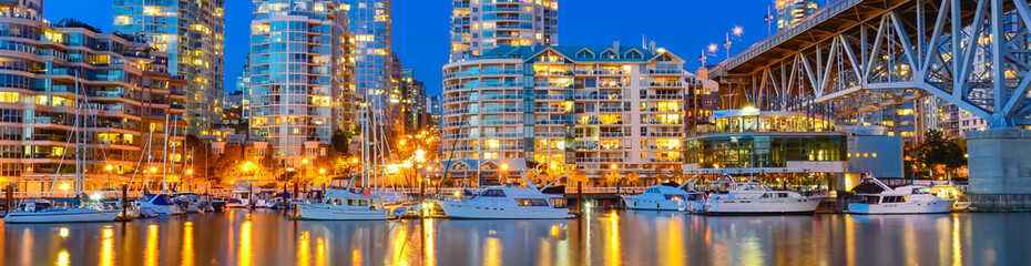 Panoramic skyscrapers reflection along False Creek riverside in Vancouver BC at blue hour