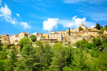 Fototapeta na wymiar View of old traditional french small provencal village Bonnieux in sunny day with blue sky on background. Popular tourist destination Provence-Alpes-Cote Azure region. Vacations in Provence
