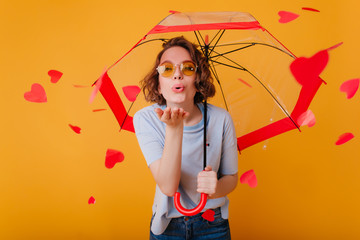 Studio portrait of white girl in sunglasses enjoying valentine's day. Indoor photo of amazing woman...