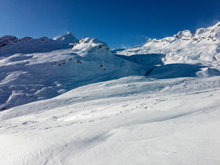 Fototapeta na wymiar A thick blanket of frozen snow covers the slopes towards the San Bernardino pass in Switzerland.
