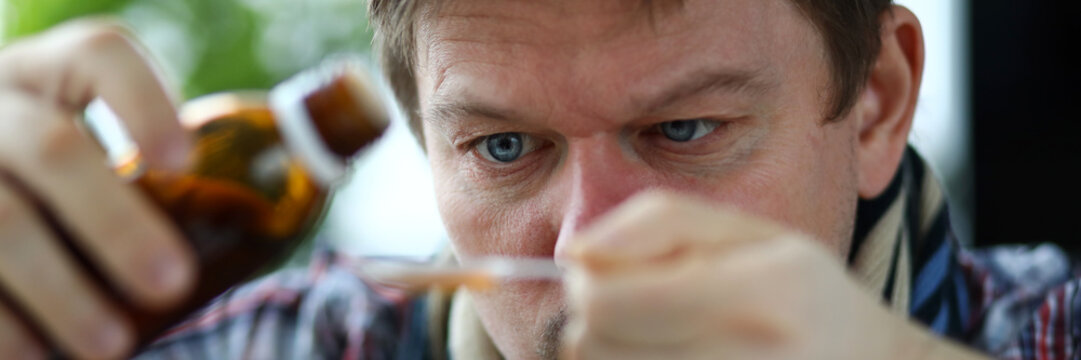 Sick man holding in hands vial with syrup portrait