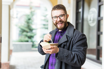 Man holding one-off plate with traditional delicious jewish food falafel made of chickpeas at the street food festival