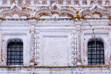 Architectural details and decoration of the white crumbling brick  facade. Empty space for icon framing two windows .  Front view close up.