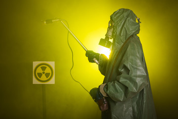 Obraz premium Radiation and danger concept - Man in the gas mask and chemical suit. The worker doing measure radioactivity