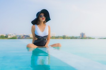 Portrait beautiful young asian woman happy smile relax around outdoor swimming pool in hotel resort