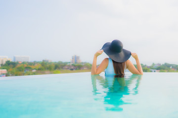 Portrait beautiful young asian woman happy smile relax around outdoor swimming pool in hotel resort