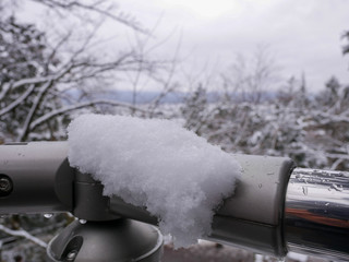 Snow captured on a stainless steel railing.