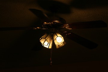 Bright bulbs hanging from a ceiling fam, dark background