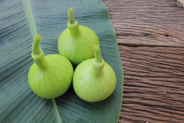 Lagenaria siceraria on banana leaf on brown wooden table.