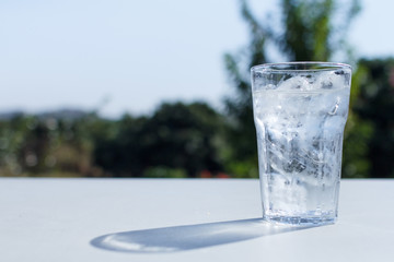 a glass of water with ice on the table.