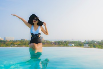 Portrait beautiful young asian woman happy smile relax around outdoor swimming pool in hotel resort