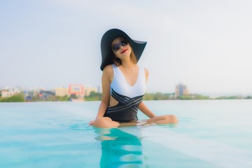 Portrait beautiful young asian woman happy smile relax around outdoor swimming pool in hotel resort