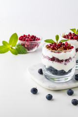Close up of two blueberry and pomegranate with vanilla greek yogurt breakfast parfait.