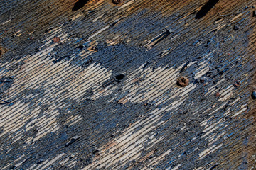 texture of old wooden painted in blue, blue peeling paint wooden desk background, peeled paint over wood boards from a boat hull