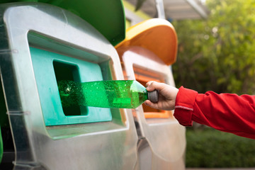 Obraz premium World Environment Day concept. Woman hand holding and putting plastic bottle waste into garbage trash.