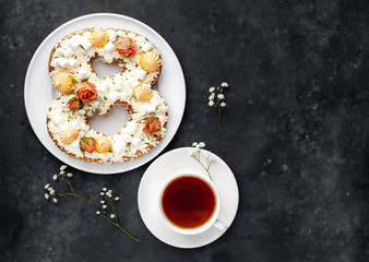 tea and cake in the form of 8 is decorated with flowers, cream cheese, marshmallows, Bizet on a stone background. romantic delicious breakfast on International Women's Day March 8