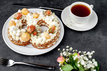 tea and cake in the form of 8 is decorated with flowers, cream cheese, marshmallows, Bizet on a stone background. romantic delicious breakfast on International Women's Day March 8