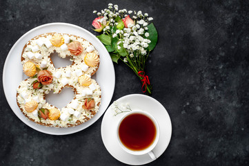 tea and cake in the form of 8 is decorated with flowers, cream cheese, marshmallows, Bizet on a stone background. romantic delicious breakfast on International Women's Day March 8