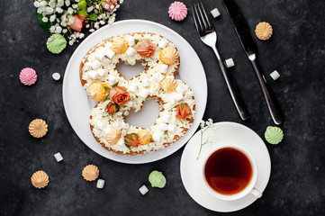 tea and cake in the form of 8 is decorated with flowers, cream cheese, marshmallows, Bizet on a stone background. romantic delicious breakfast on International Women's Day March 8