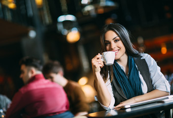 Portrait of pretty woman drinking coffee or tea in a cafe. Pleasure time