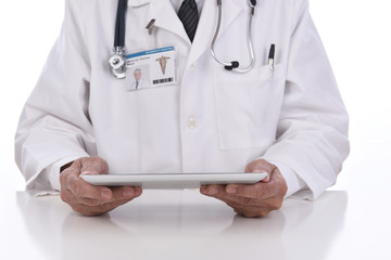 Closeup of a doctor holding a tablet computer as he sits at his desk. Focus is on Tablet, ID TAGis computer generated.