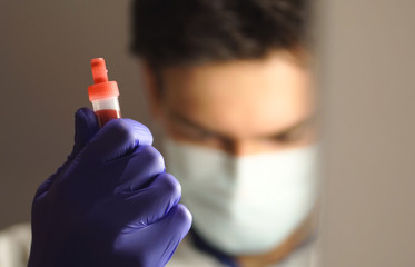 blood sample in the hand of a clinical doctor in the background