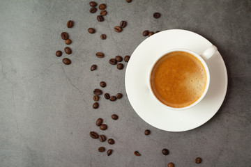 cup of coffee with beans on back background