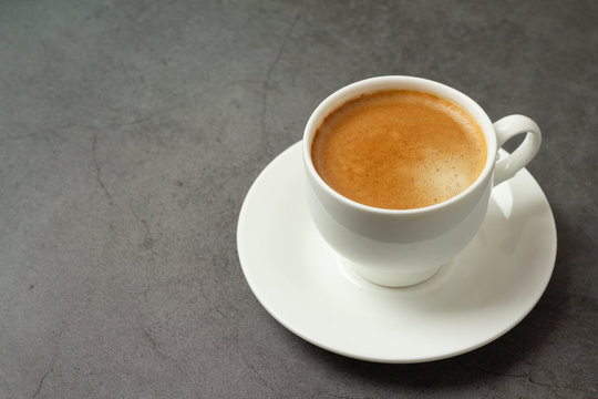 black coffee in a white cup on a black background close-up