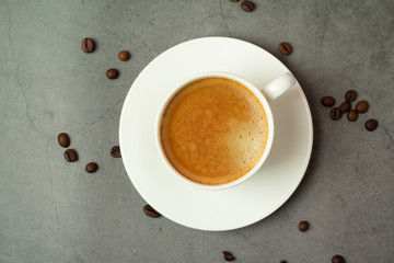 cup of black coffee and coffee beans on a black background