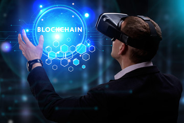 Business, Technology, Internet and network concept. Young businessman working on a virtual screen of the future and sees the inscription: Blockchain