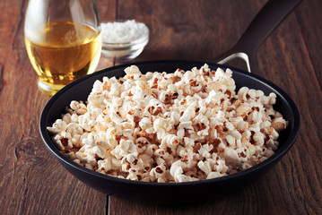 Popcorn in a frying pan on a wooden kitchen table
