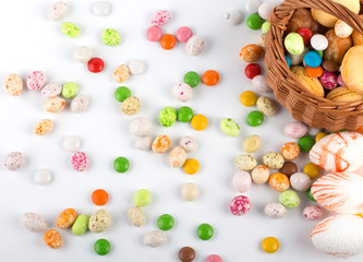 Easter colored candies and sweets similar to bird eggs on a white background